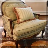 F11. Upholstered arm chair with carved floral decoration. 38”h x 36”w x 32”d 